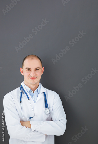 Portrait of confident doctor on gray background looking at the c © Dmytro Panchenko