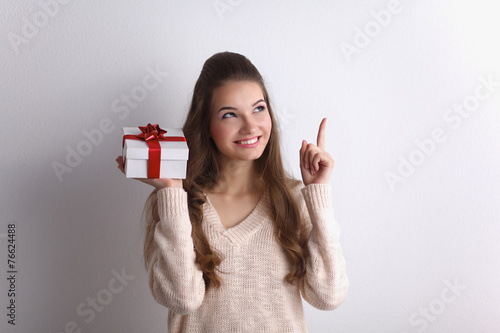 Young woman happy smile hold gift box in hands,standing over