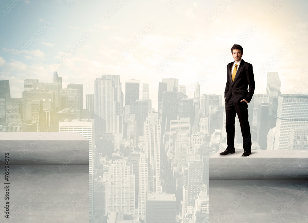 Businessman standing on the edge of rooftop Businessman standing on the edge of rooftop