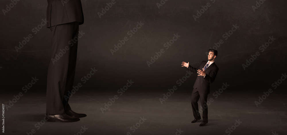 Fototapeta premium Huge man with small businessman standing at front concept