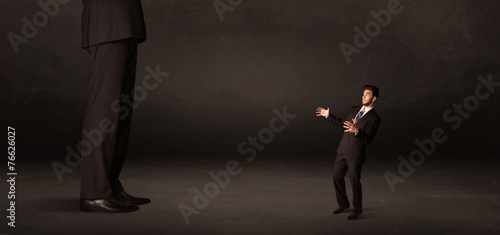 Huge man with small businessman standing at front concept