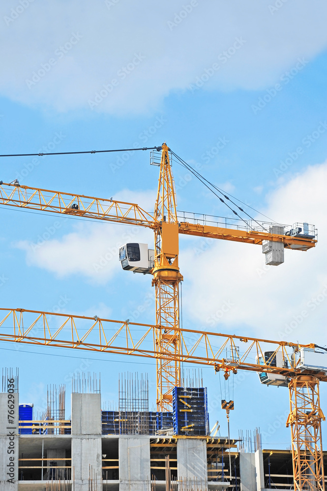 Crane and building construction site against blue sky Crane and building construction site against blue sky