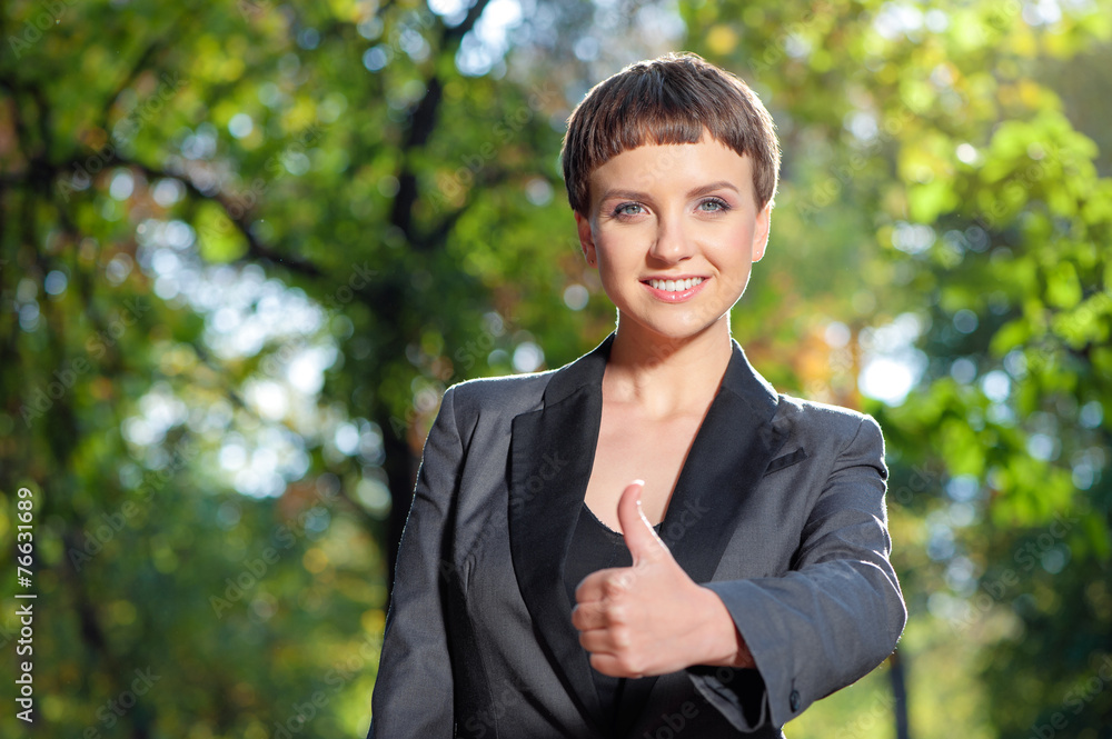 young woman in formalwear showing her thumb up and smiling young woman in formalwear showing her thumb up and smiling