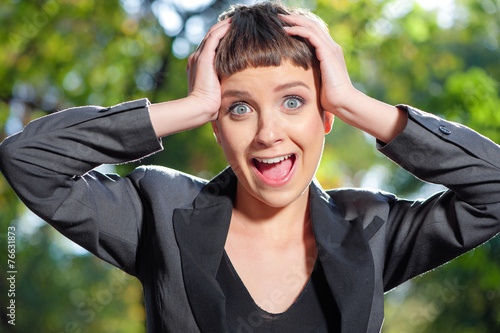 Frustrated young woman in formalwear holding head in hands and l photo