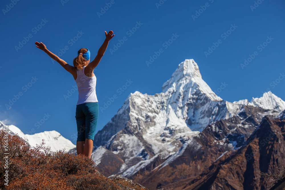 Young woman is practicing yoga against Himalaya mountains