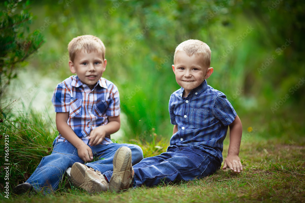 Two brothers hugging each other outdoor, smiling and laughing Two brothers hugging each other outdoor, smiling and laughing