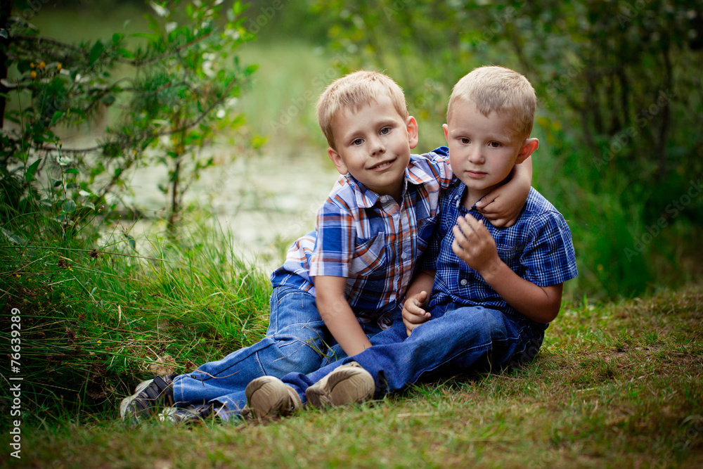Two brothers hugging each other outdoor, smiling and laughing Two brothers hugging each other outdoor, smiling and laughing