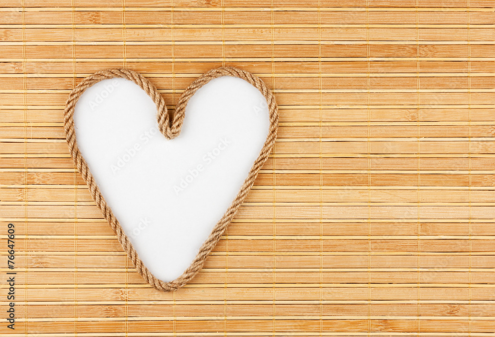 Symbolic heart made of rope lying on a bamboo mat Symbolic heart made of rope lying on a bamboo mat