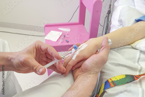 Young boy getting glucose injection in vain