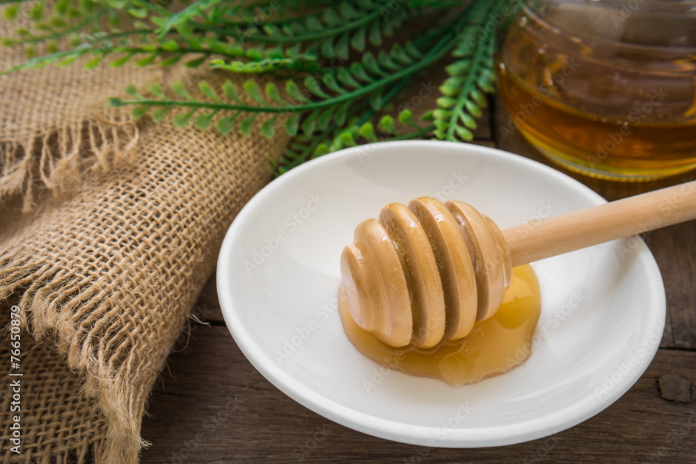 Honey dipper on plate and jar Honey dipper on plate and jar