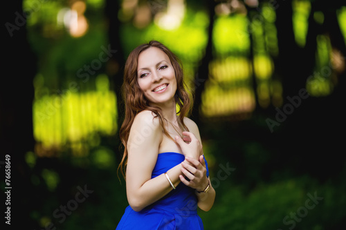 Young cheerful woman posing in park