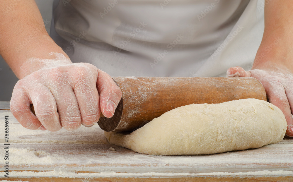 Woman  preparing dough  on  wooden table.