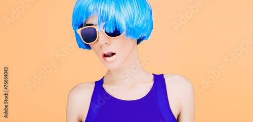 Fantastic fashion lady in blue wig and glasses on yellow backgro