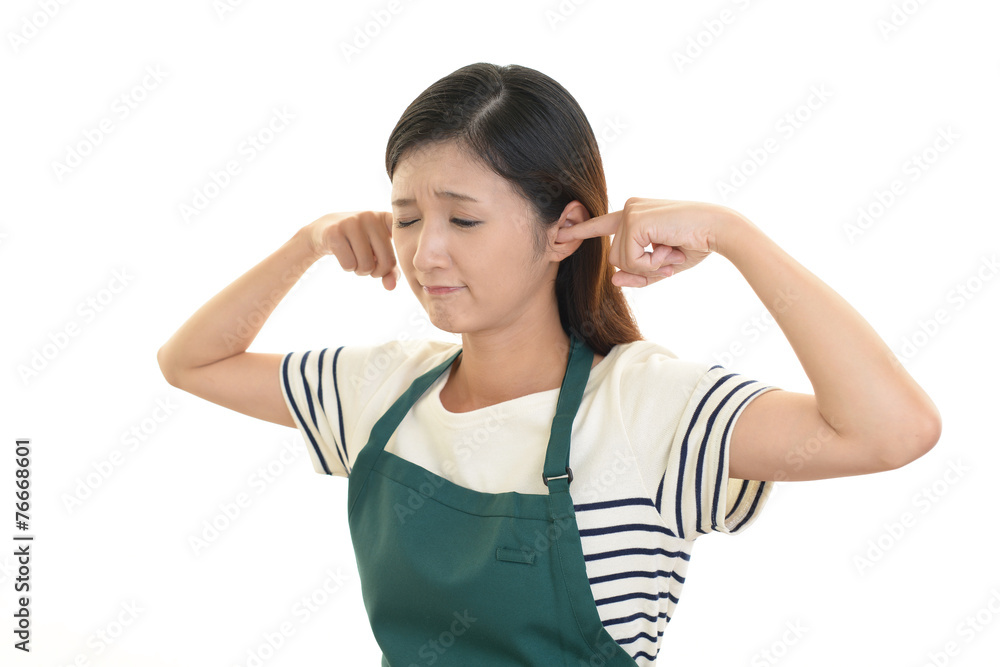 耳をふさぐ女性