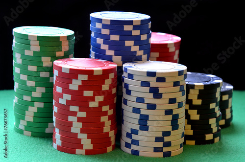 Red, blue, green, white and black poker chips columns