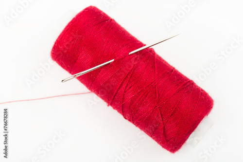 Needle, Pile of colored bobbin of lurex thread isolated on white