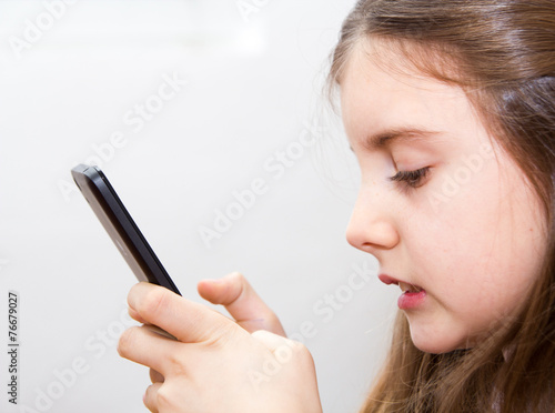 Cute little girl using modern smartphone