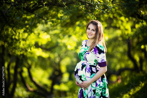 Fototapeta Naklejka Na Ścianę i Meble -  Beautiful pregnant woman in sunny park