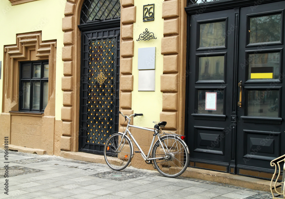 Old bicycle parked in front of a beautiful decoration old buildi