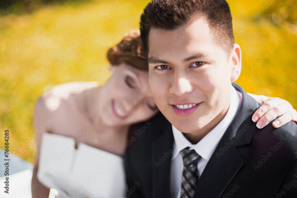 the bride and groom sit in the park and petting the bride and groom sit in the park and petting