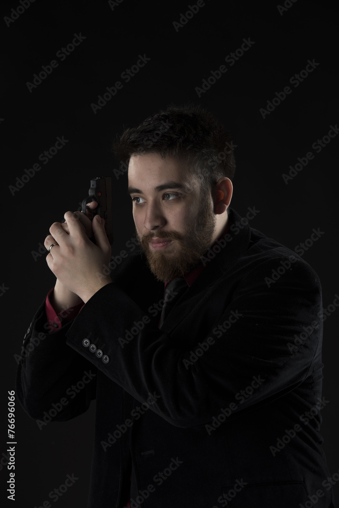 Goatee Man in Black Suit Holding Weapon Goatee Man in Black Suit Holding Weapon