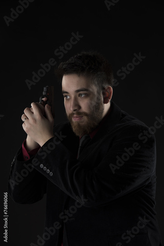 Goatee Man in Black Suit Holding Weapon © vlorzor