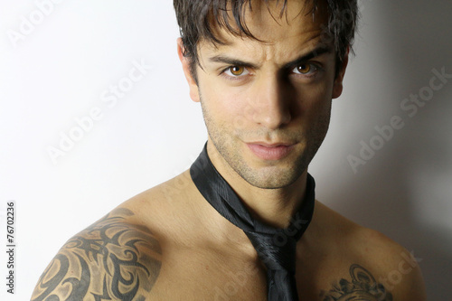 portrait of a beautiful bare-chested man with a tie
