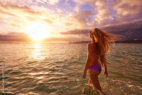 Carefree woman in the sunset on the beach.