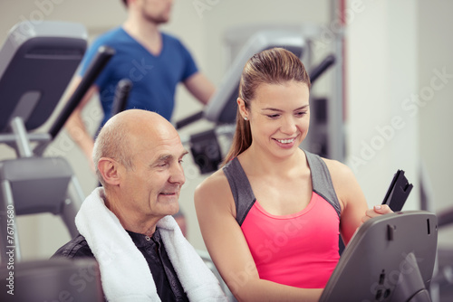 trainerin im fitness-studio ber  t einen   lteren kunden