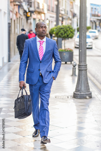 Black businessman walking on the street with a modern briefcase