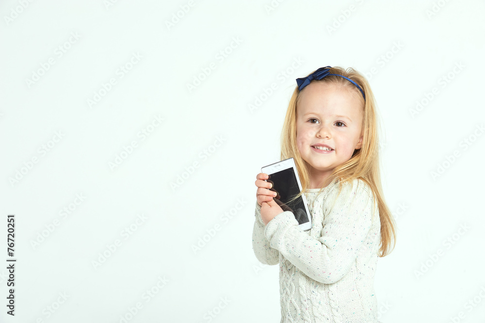 Cute little girl smiling and uses a smartphone, phone. Cute little girl smiling and uses a smartphone, phone.