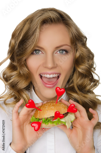 Smiling young woman with hamburger from hearts