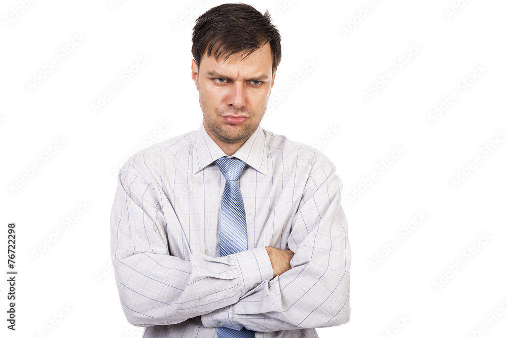 Portrait of young unhappy businessman with arms folded
