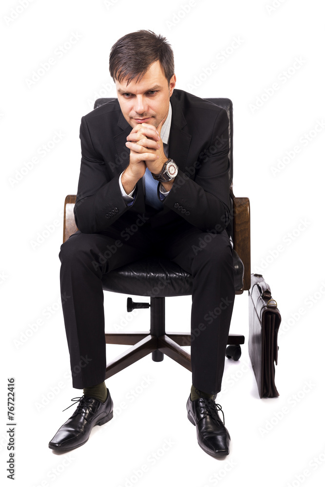 Thoughtful businessman sitting in an armchair Thoughtful businessman sitting in an armchair