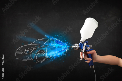 Worker with airbrush gun painting hand drawn car lines
