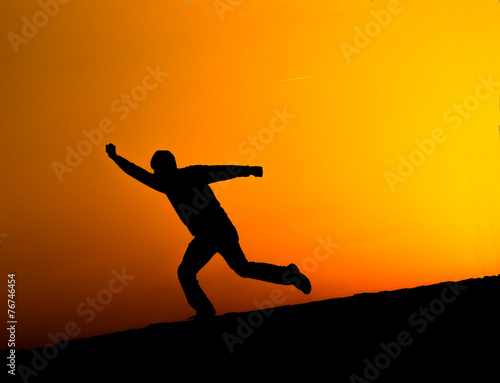 Silhouette of man running at sunset