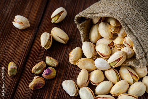 Pistachio nuts in a bag on an old wooden surface