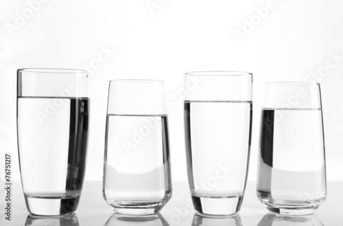 Glasses of water on light background