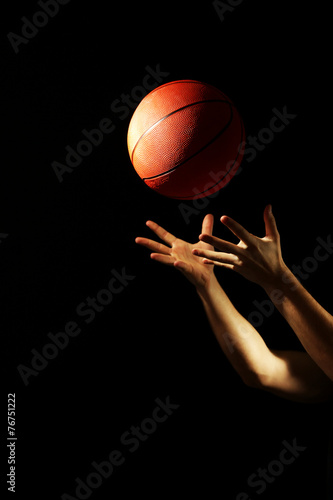 Basketball player with ball, on dark background © Africa Studio