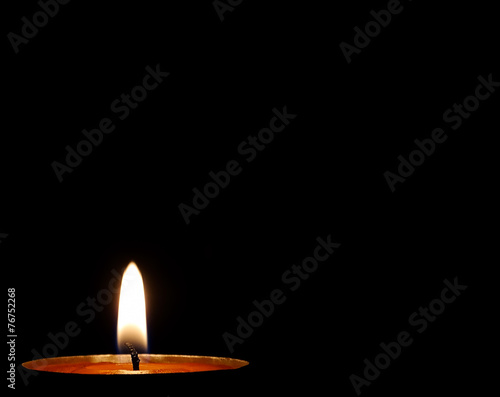 Burning candle on a black background