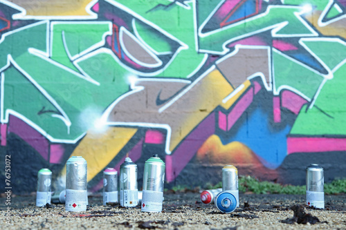 bombes de peinture devant un graffiti
