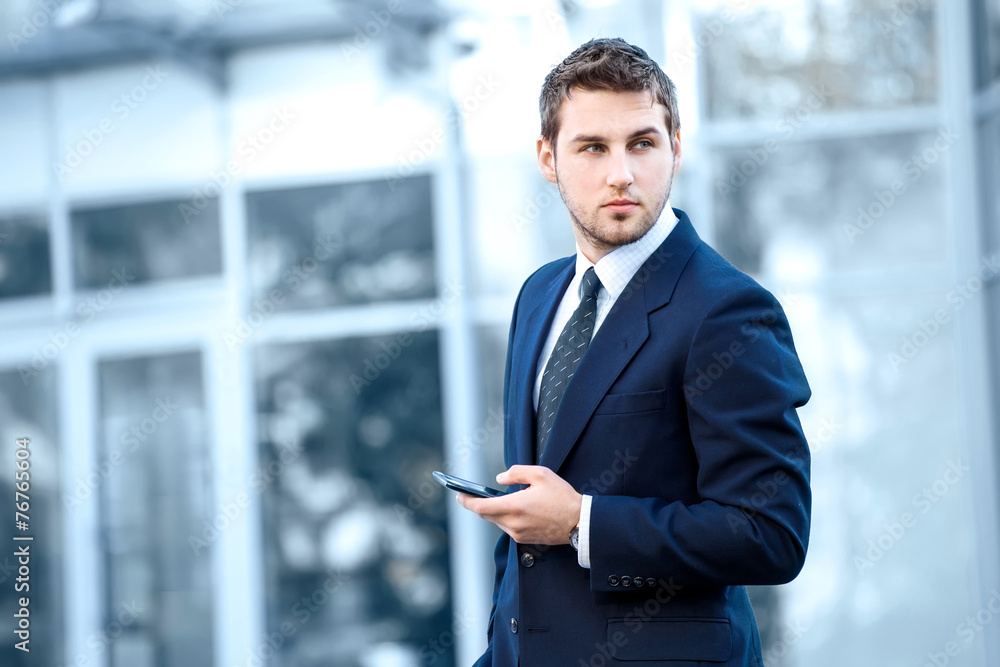 Attractive young businessman using a cell phone. Taken in front Attractive young businessman using a cell phone. Taken in front