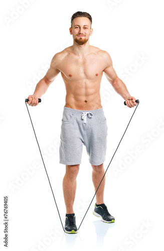 Athletic attractive man jumping on a rope on the white