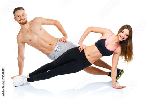 Athletic attractive couple - man and woman doing fitness exercis