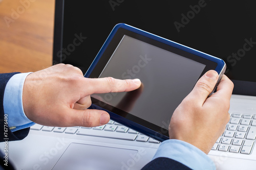 Businessman working on laptop and tablet