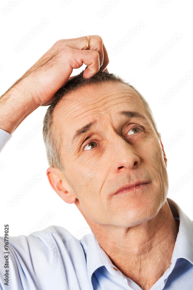Obraz premium Confused man scratching his head