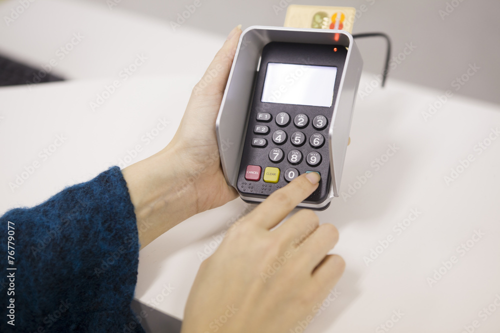 Women who are entering the PIN number of credit card Women who are entering the PIN number of credit card