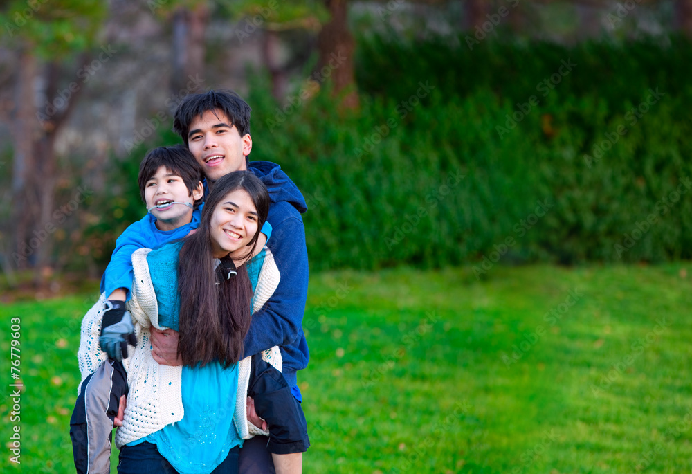 Disabled biracial child riding piggy back on his sister, family Disabled biracial child riding piggy back on his sister, family