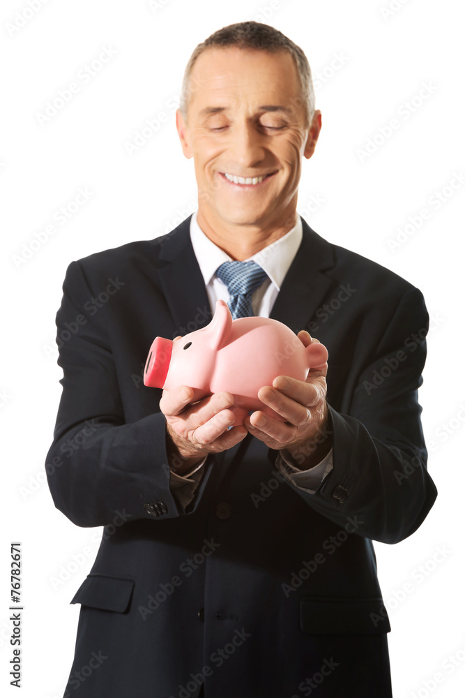 Portrait of cheerful businessman holding piggybank Portrait of cheerful businessman holding piggybank