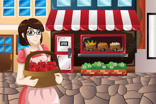 Female store owner standing in front of her store carrying a bas